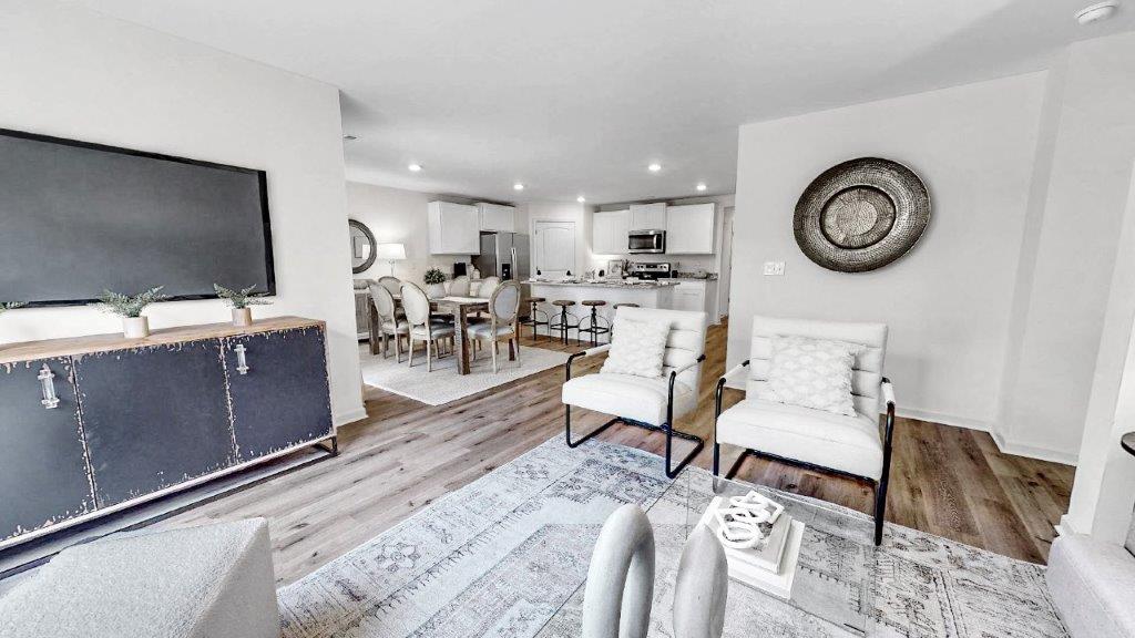 a different view of the living room that shows part of the living room that opens to the dining room and the kitchen