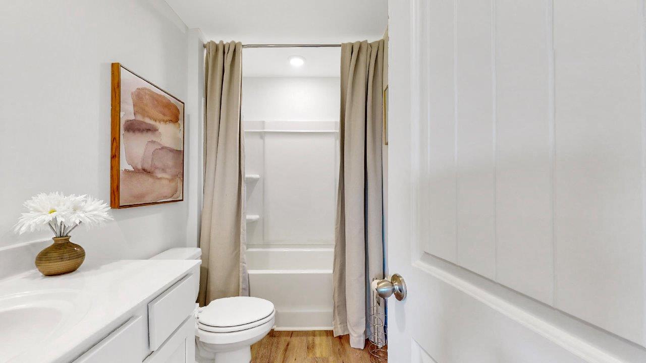 the second bathroom features a single vanity with ample counter space, a toilet and a tub shower