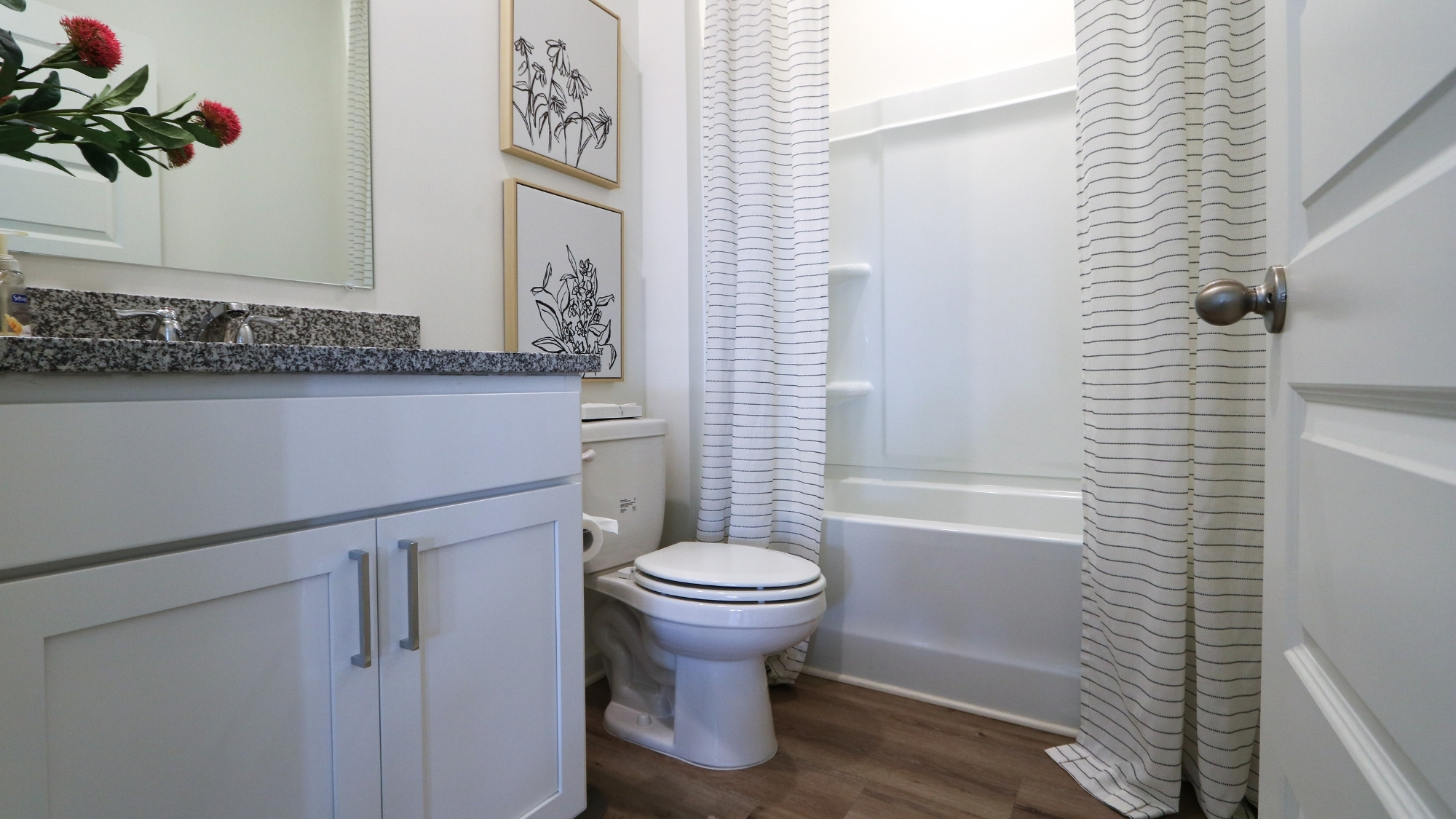 The expansive primary bedroom on the second level features a spacious, king-sized bed. Additionally, there are two oversized night tables, a dresser, and two large guest chairs for added comfort and convenience.