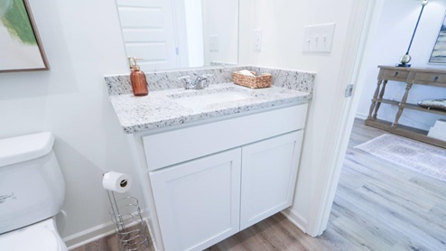 The Rhett plan is a well-designed single-level layout with 4 bedrooms and 2 bathrooms, encompassing 1,774 square feet for practical living. One standout feature of the Rhett plan is the seamless integration of the kitchen, breakfast area, and great room in an open concept layout, which is perfect for hosting guests. The kitchen is equipped with granite countertops, stainless steel appliances, and a pantry for added convenience and modern style. The spacious Living Area features trey ceilings and leads to a shaded covered patio, creating a welcoming space for relaxation and entertaining. Bedroom One suite offers a private retreat with trey ceilings, a luxurious shower, separate garden tub, double marble vanity, private water closet, and a large walk-in closet for added comfort and luxury. For convenience and storage, the plan includes a two-car garage and a laundry room. In addition to Bedroom One suite, there are 3 other bedrooms and another full bathroom, providing ample space for family and guests. Furthermore, the home comes with a one-year builder's warranty, ensuring peace of mind for the new homeowners. Furthermore, every home is accompanied by a one-year builder's warranty to provide you with added peace of mind. It's important to note that our smart home technology package is included as part of your new home. The Smart Home Technology Package we offer is designed for effortless use and provides unmatched convenience, allowing you to easily control various essential features with just a simple touch. Some of the features of this package include lighting automation, an IQ panel, a video doorbell, keyless front door entry, and the ability to manage the temperature from the comfort of your phone. Give us a call and schedule your personal guided tour of the Rhett today!