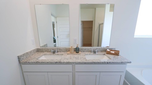 The Rhett plan is a well-designed single-level layout with 4 bedrooms and 2 bathrooms, encompassing 1,774 square feet for practical living. One standout feature of the Rhett plan is the seamless integration of the kitchen, breakfast area, and great room in an open concept layout, which is perfect for hosting guests. The kitchen is equipped with granite countertops, stainless steel appliances, and a pantry for added convenience and modern style. The spacious Living Area features trey ceilings and leads to a shaded covered patio, creating a welcoming space for relaxation and entertaining. Bedroom One suite offers a private retreat with trey ceilings, a luxurious shower, separate garden tub, double marble vanity, private water closet, and a large walk-in closet for added comfort and luxury. For convenience and storage, the plan includes a two-car garage and a laundry room. In addition to Bedroom One suite, there are 3 other bedrooms and another full bathroom, providing ample space for family and guests. Furthermore, the home comes with a one-year builder's warranty, ensuring peace of mind for the new homeowners. Furthermore, every home is accompanied by a one-year builder's warranty to provide you with added peace of mind. It's important to note that our smart home technology package is included as part of your new home. The Smart Home Technology Package we offer is designed for effortless use and provides unmatched convenience, allowing you to easily control various essential features with just a simple touch. Some of the features of this package include lighting automation, an IQ panel, a video doorbell, keyless front door entry, and the ability to manage the temperature from the comfort of your phone. Give us a call and schedule your personal guided tour of the Rhett today!
