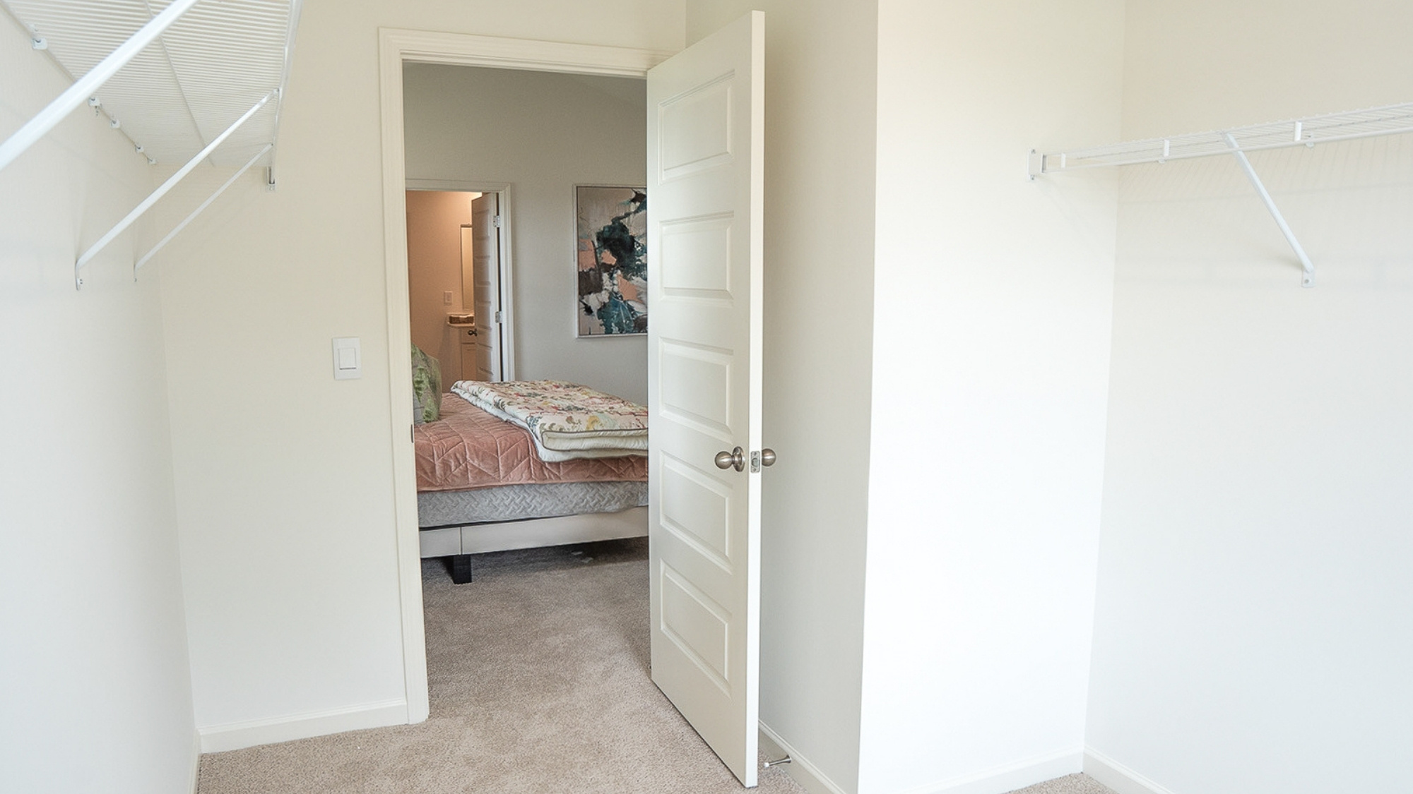 The spacious living room, shown here staged with a large sectional, opens up to the open concept dining and kitchen areas.