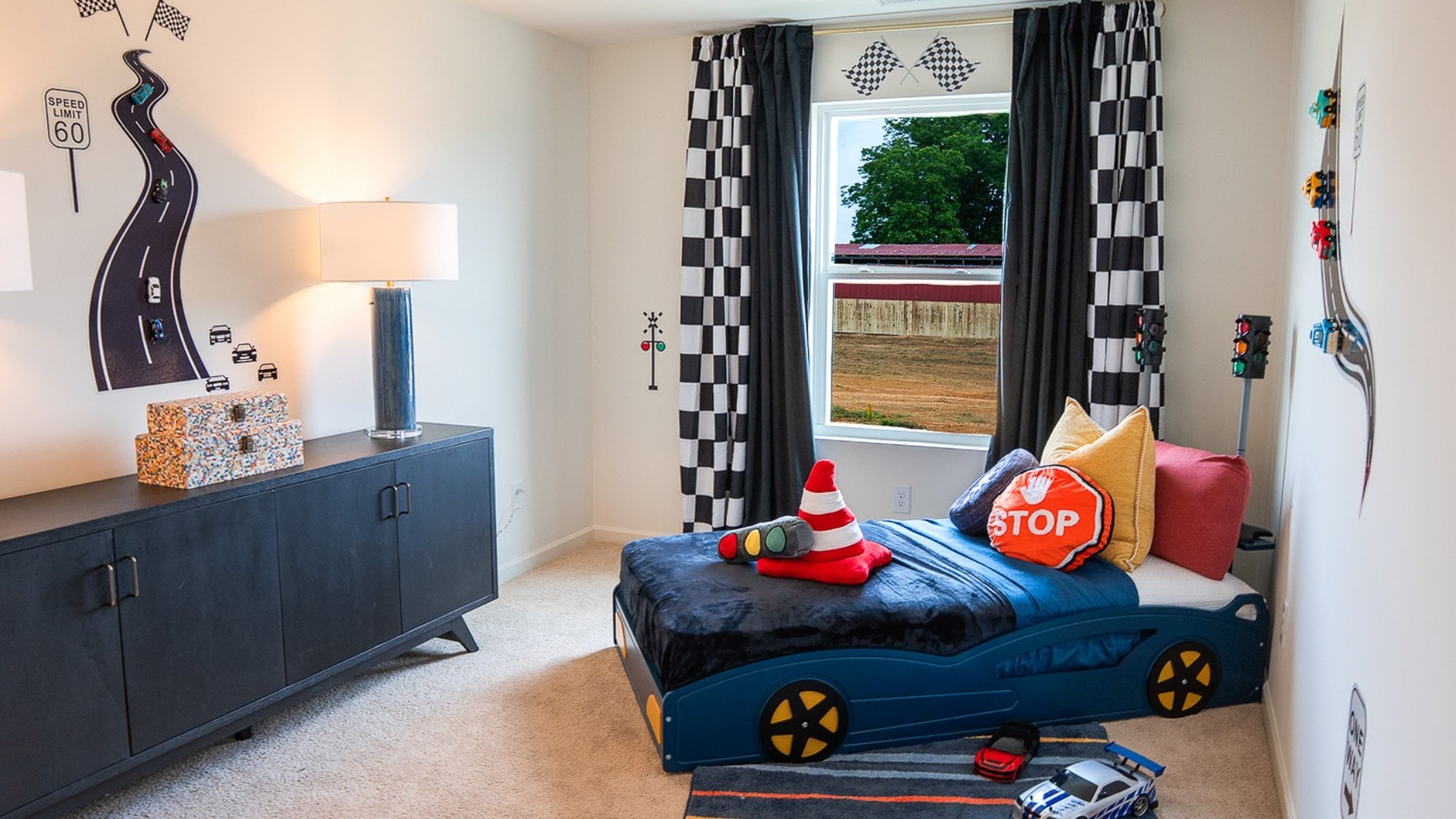 The second bedroom is shown here staged with a queen sized bed, two nightstands, and an armchair.