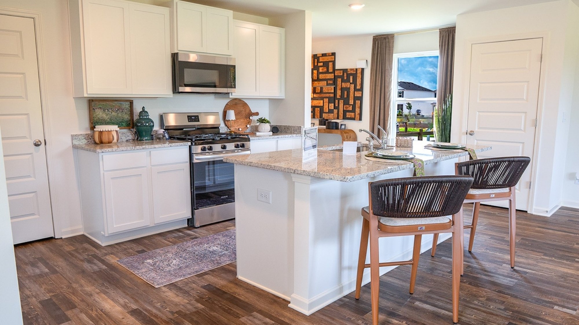 The roomy modern kitchen features stainless applianes and an island eating area large enough for 4 barstools.