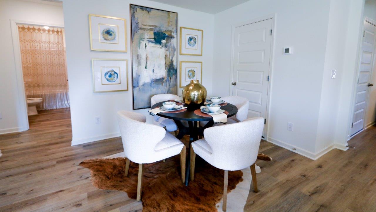 The dining nook, shown here staged with a modern dining table, features enough space for the whole family to eat together.