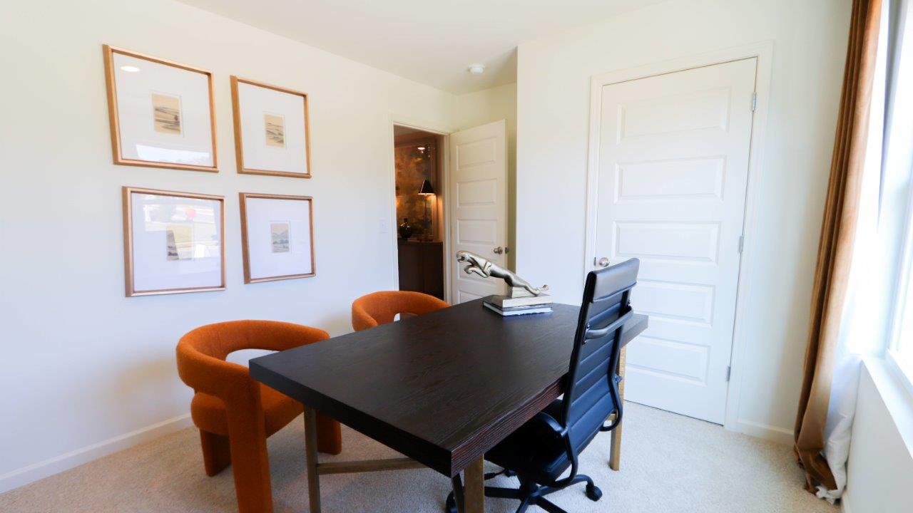 The fifth bedroom is shown here staged as a home office, with ample room for a large desk and 2 meeting chairs.