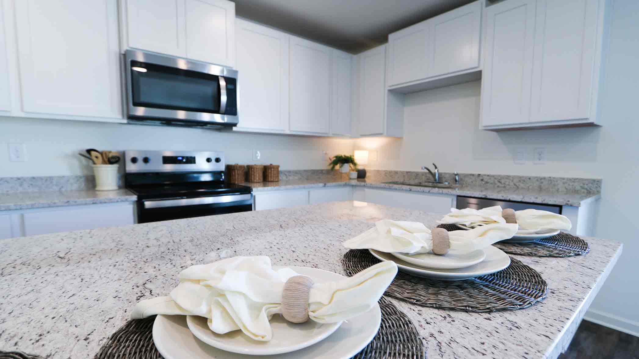 A modern kitchen featuring white cabinets and vinyl hardwood floors, creating a bright and inviting atmosphere.