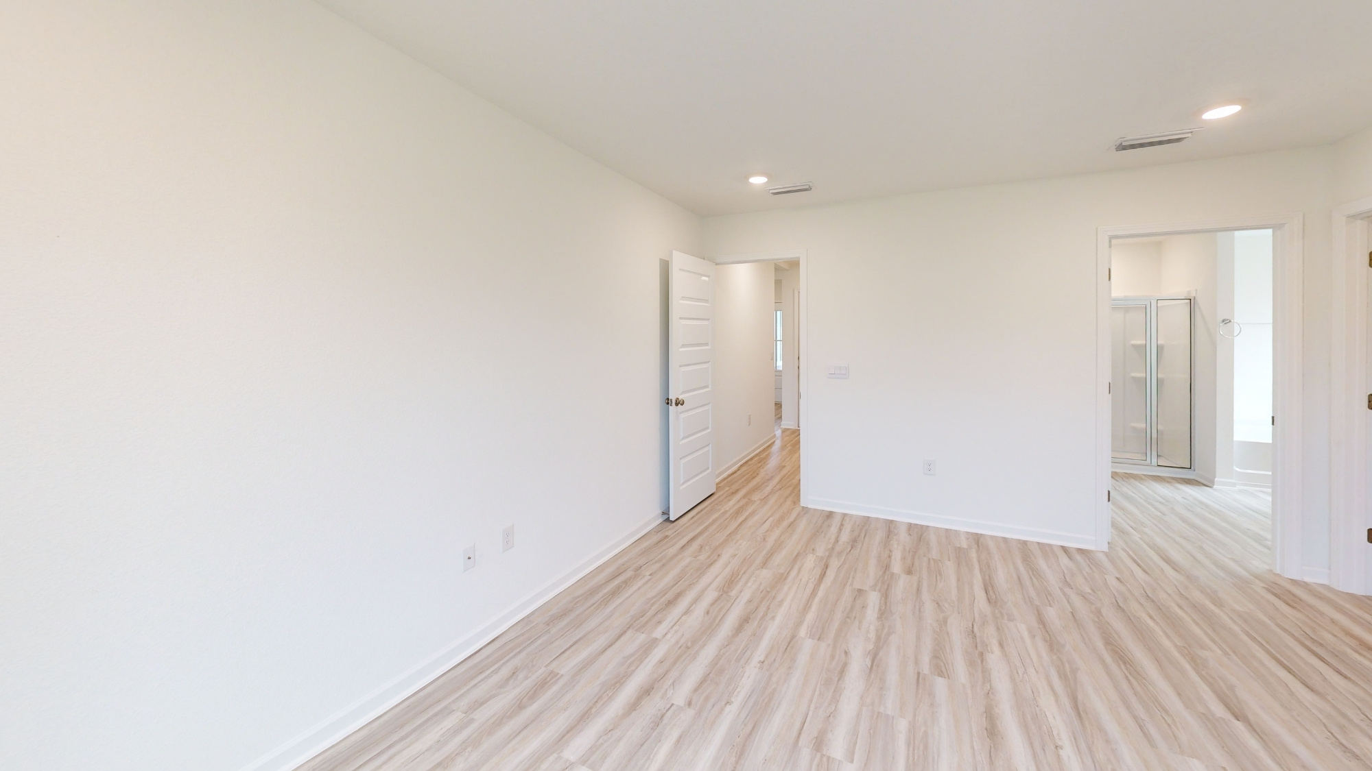 The primary bedroom, which features an ensuite bathroom and a large walk in closet.
