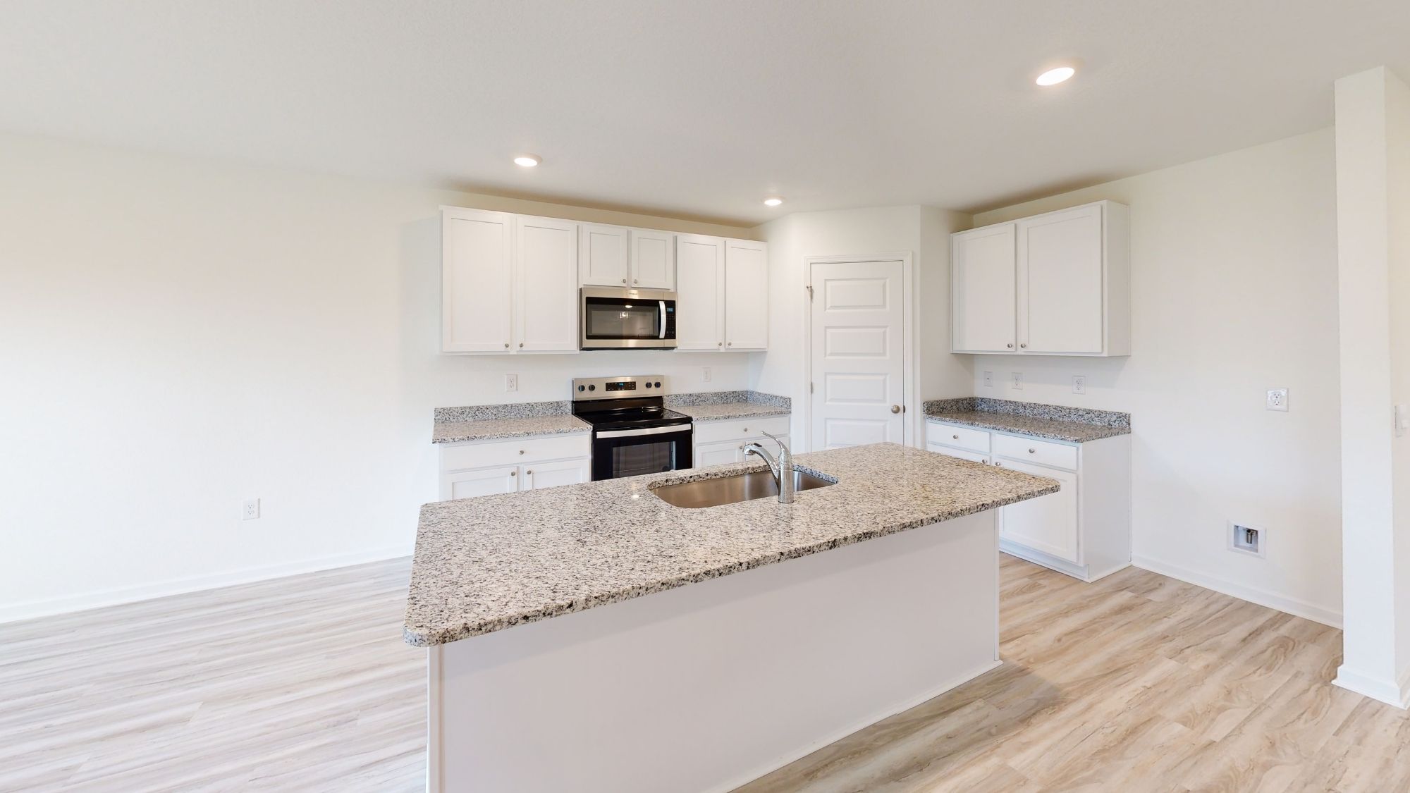 The kitchen is open to the living and dining areas, and features modern finishes.