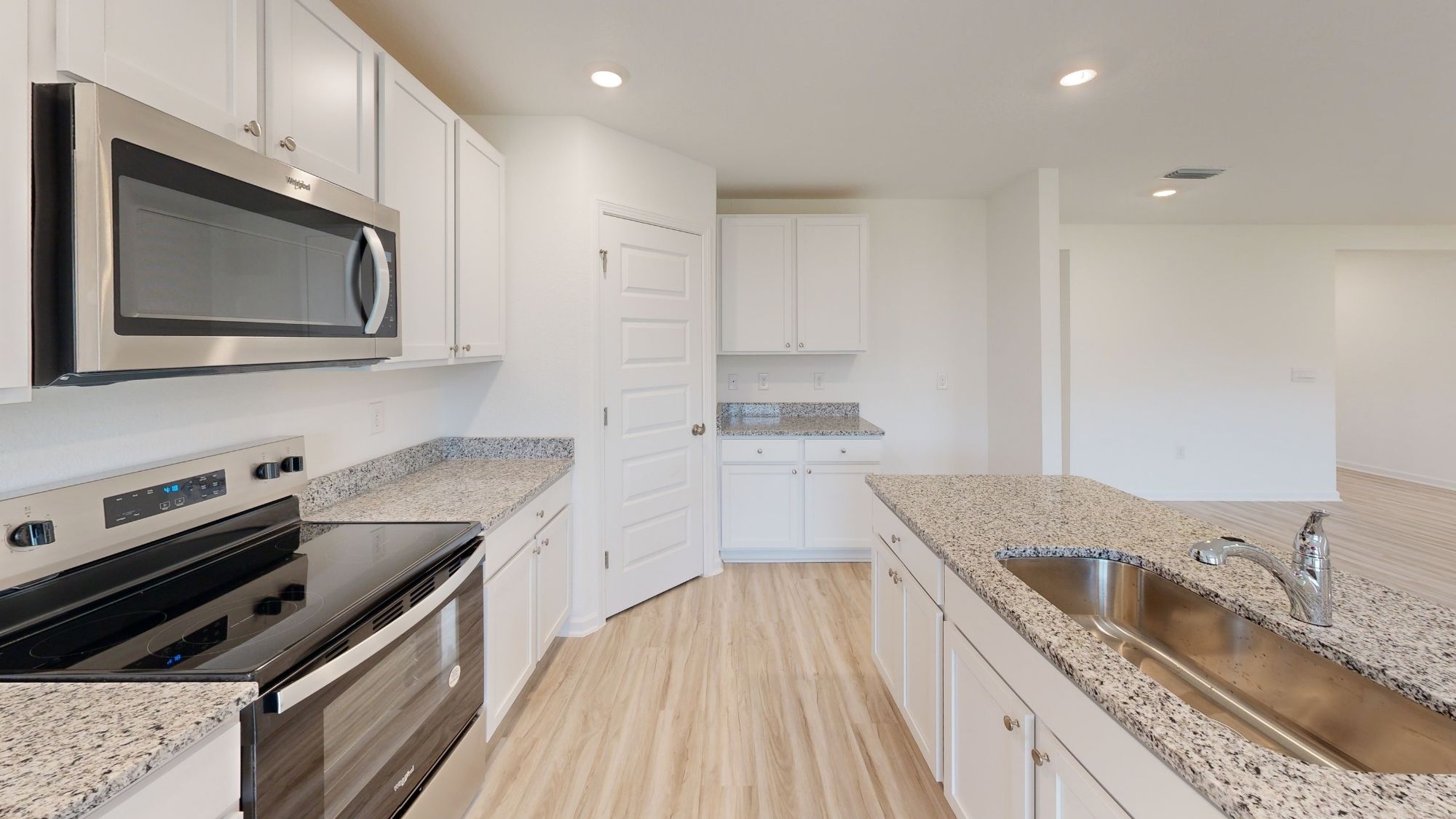Contemporary kitchen featuring sleek stainless steel appliances and a seamless transition into the dining and living areas.