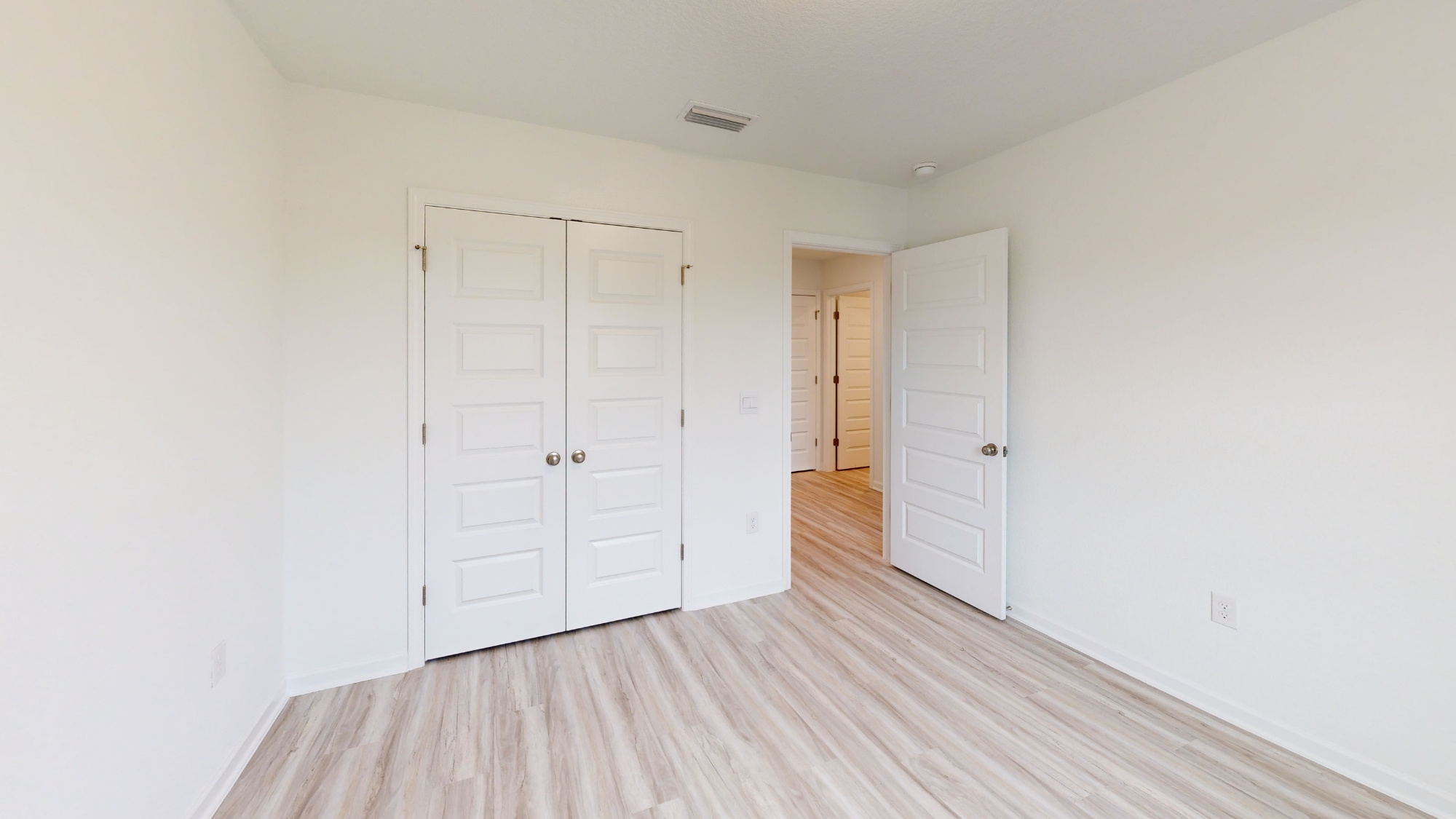 Off of the living room you will find the laundry room and two bedrooms, next to a full bathroom. Shown here is bedroom 3.