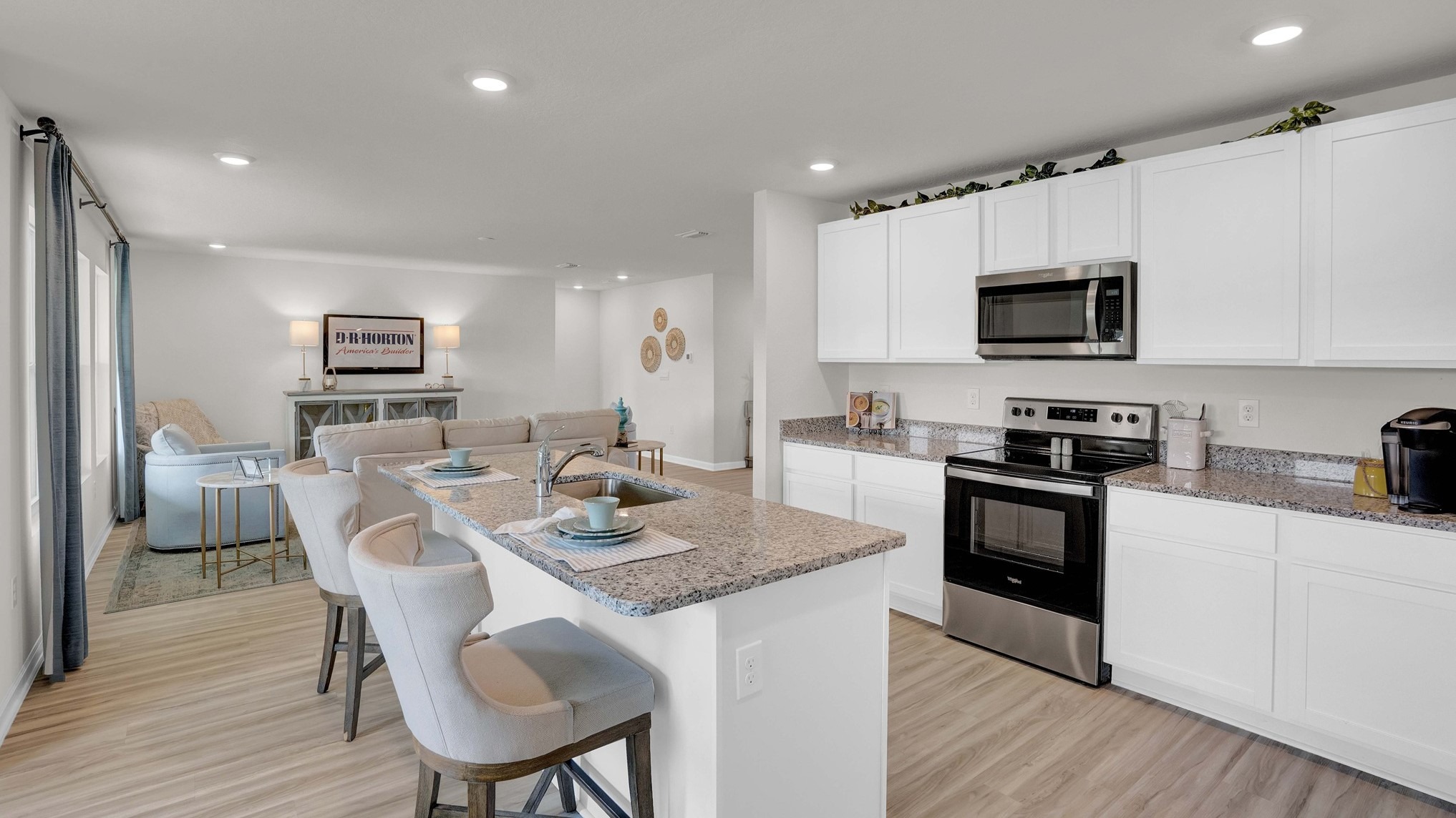 This is another perspective of the kitchen, highlighting the island with barstools and the breakfast area.