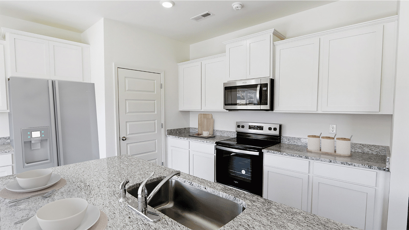 Bright and modern kitchen featuring sleek cabinetry and granite countertops, perfect for cooking and entertaining.