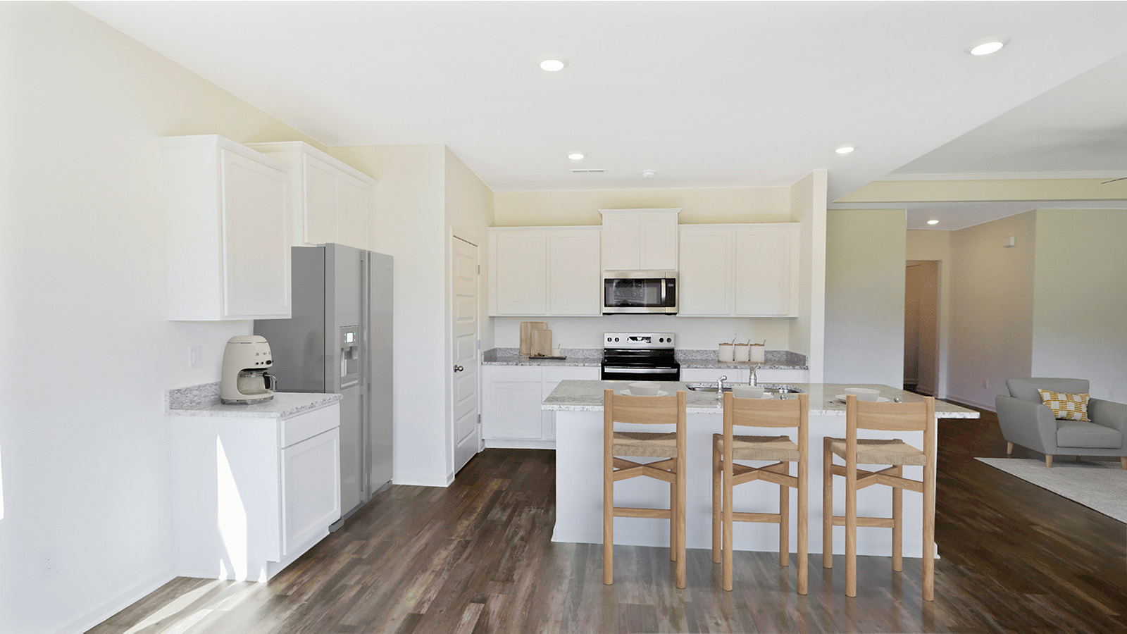 This kitchen features a bright and modern design with sleek white cabinetry. The spacious granite countertops provide ample space for cooking and entertainment. It is a perfect environment for both preparing meals and hosting guests.