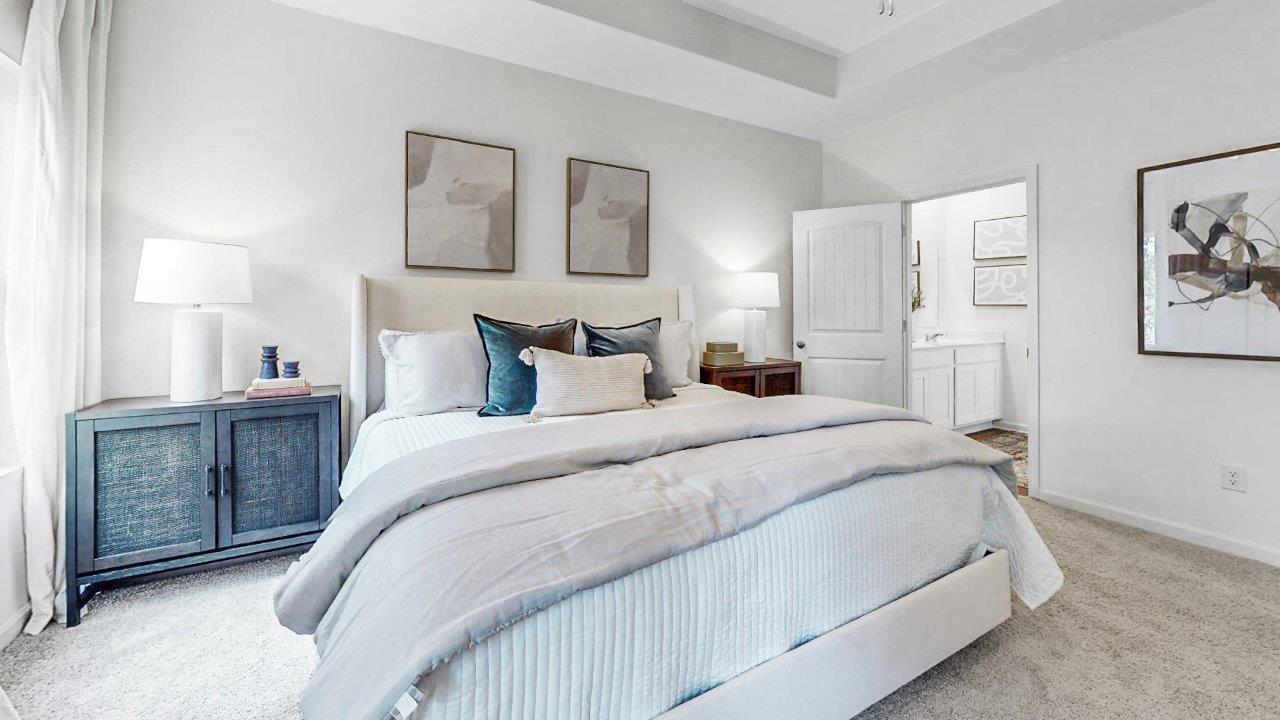 Primary bathroom features a double vanity, a walk in shower and the walk in closet