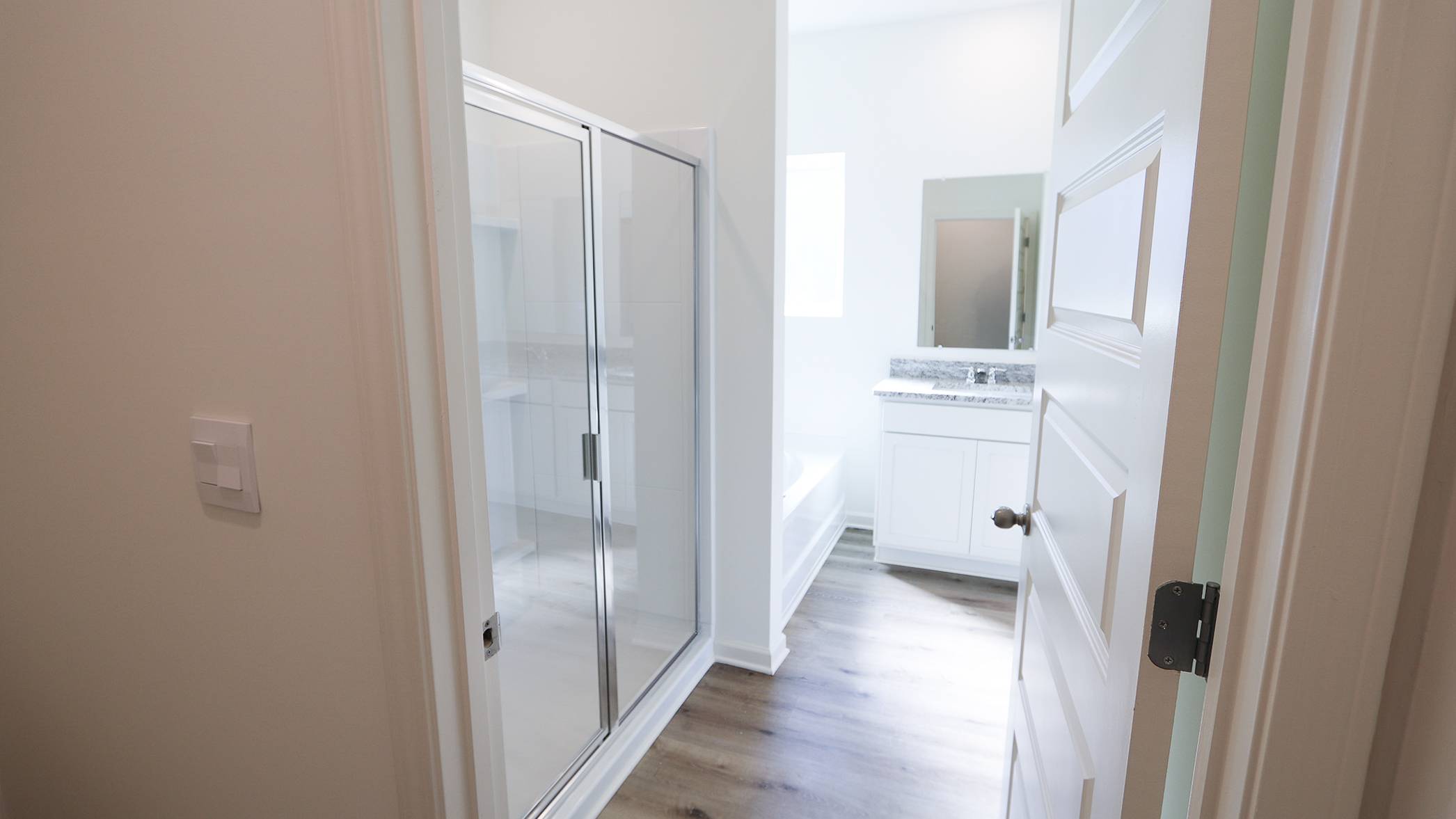 Modern bathroom with glass shower enclosure and white vanity.