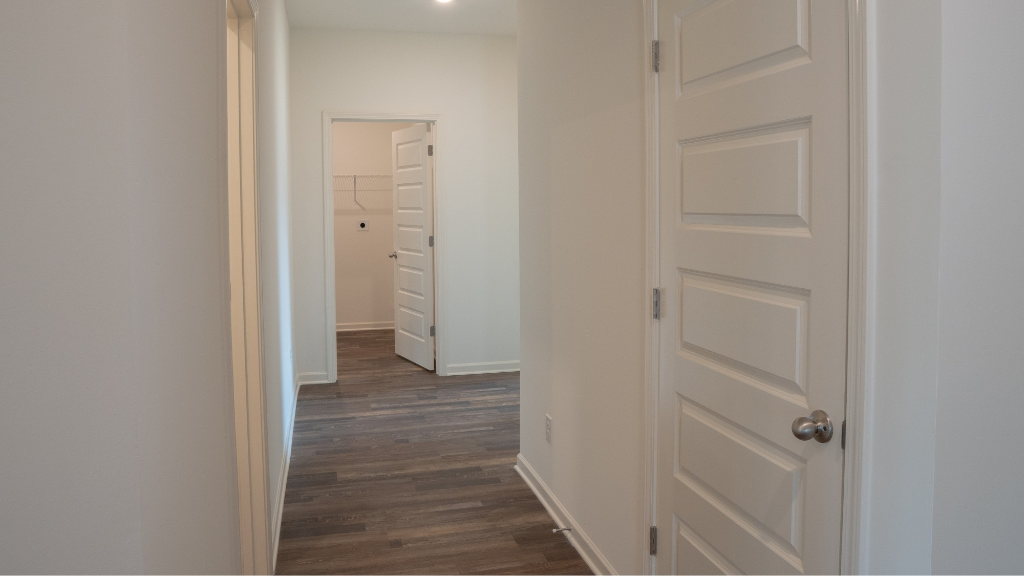 Open and tranquil bedroom with wood finish flooring and a bright, spacious en-suite bath that enhances the sense of retreat.