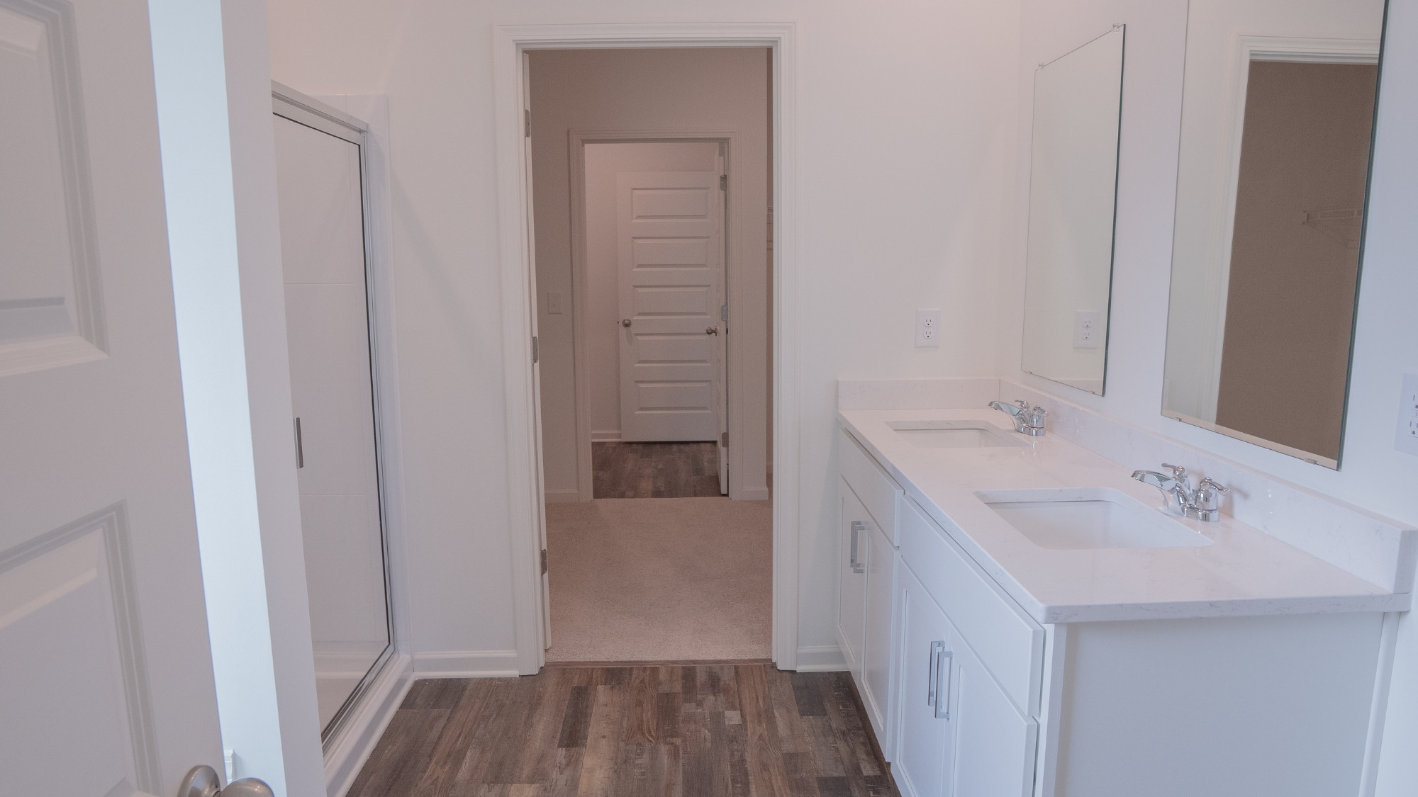 Elegant bathroom off the primary suite, complete with a double vanity, standalone tub, and generous shower space.