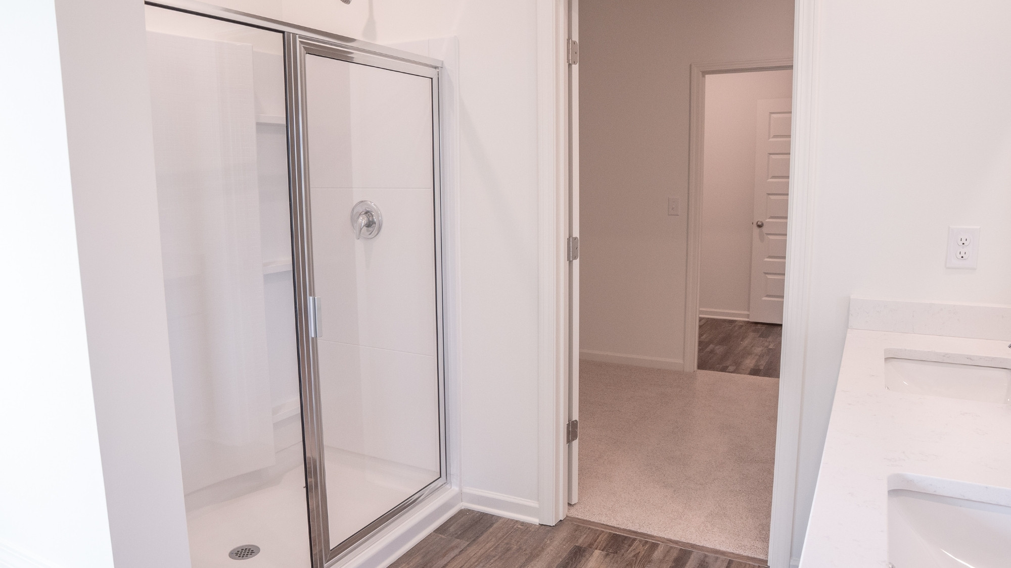 Open and peaceful primary suite with a king bed, two nightstands, and a dresser, all arranged to emphasize the room’s scale and brightness.