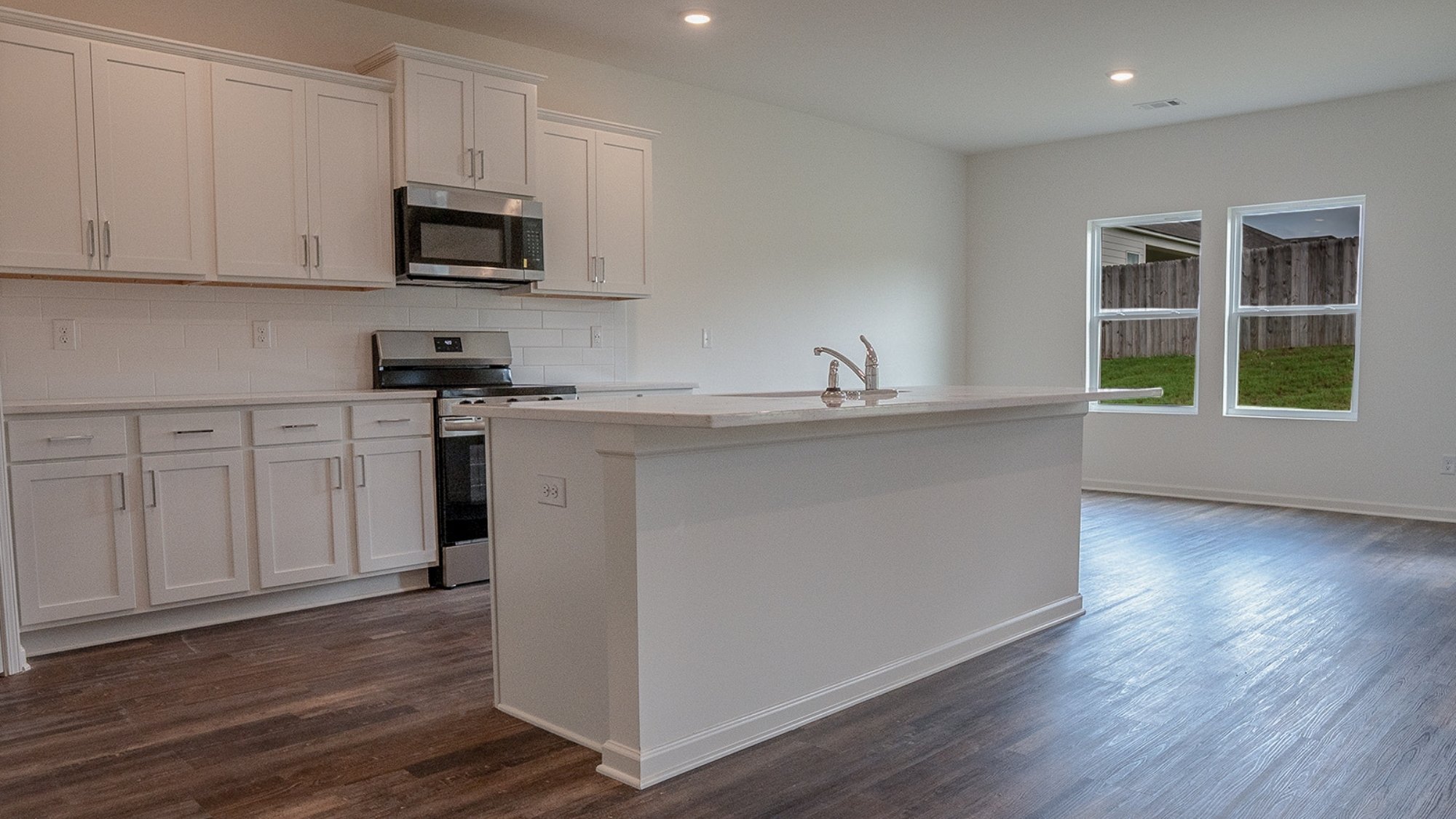 Contemporary kitchen with a central island that includes a stainless steel sink, providing extra counter space and a focal point in the design.