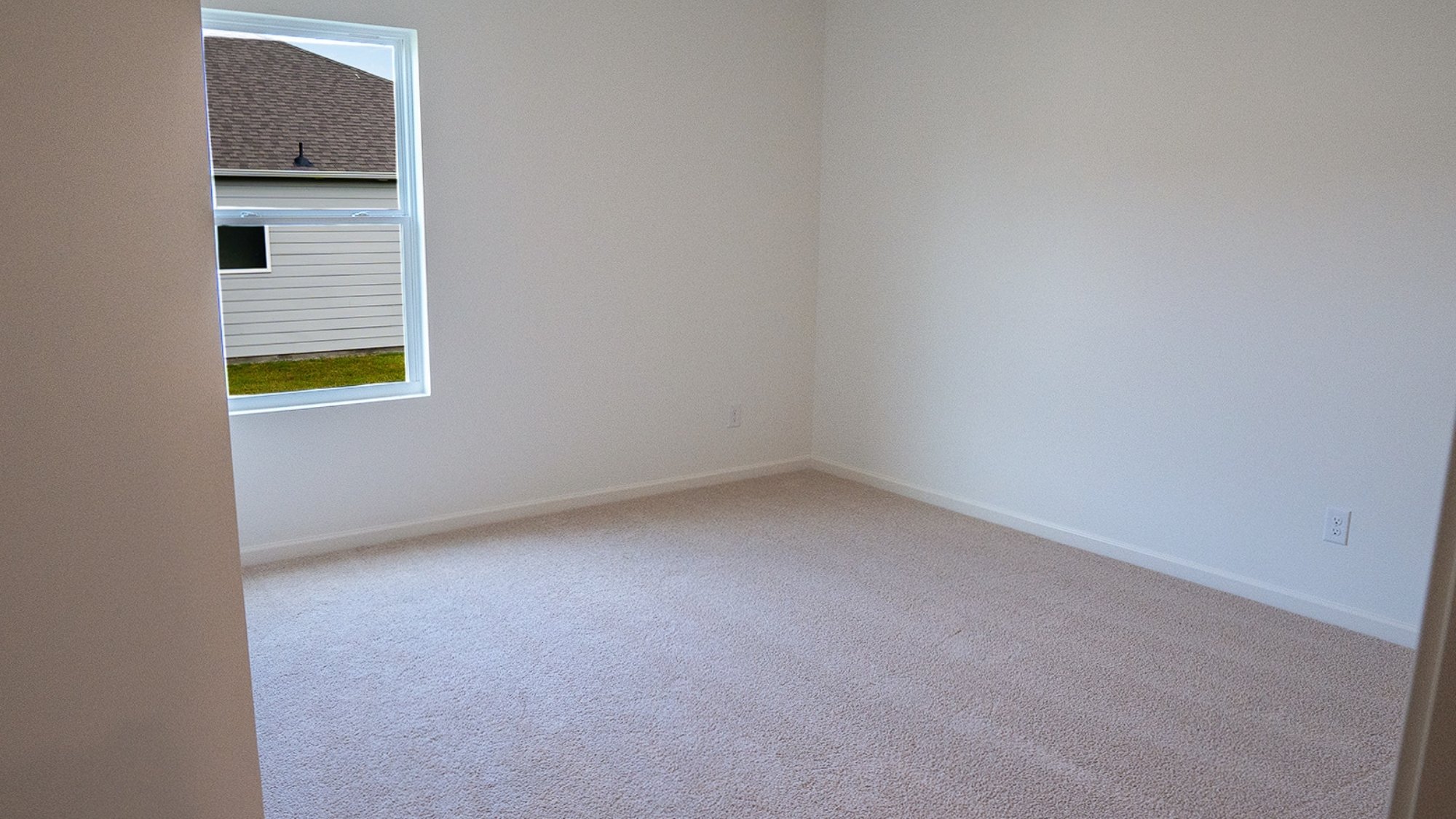 Spacious bedroom featuring a bed, two nightstands, and a closet, with large windows and carpeted floors for a warm, inviting feel.