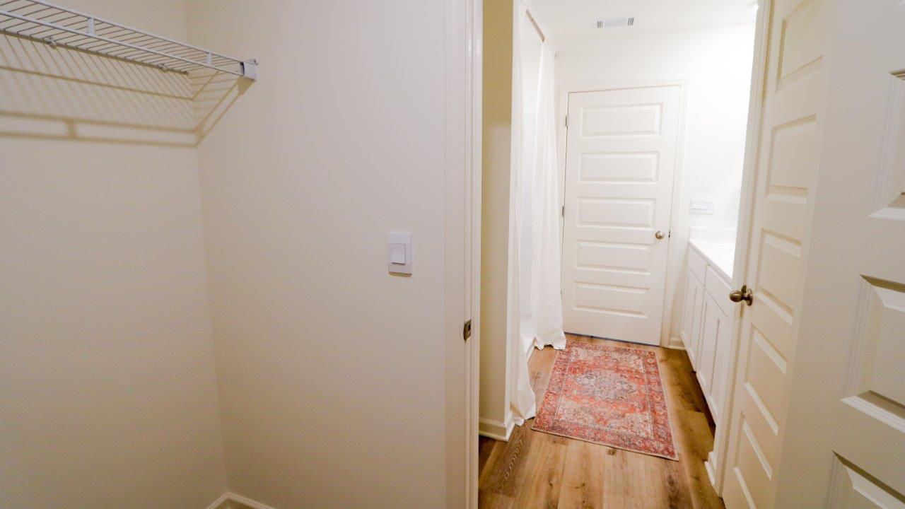The primary bedroom features a spacious walk-in closet located at the back of the bathroom. This walk-in closet provides ample space for storing clothes and accessories.