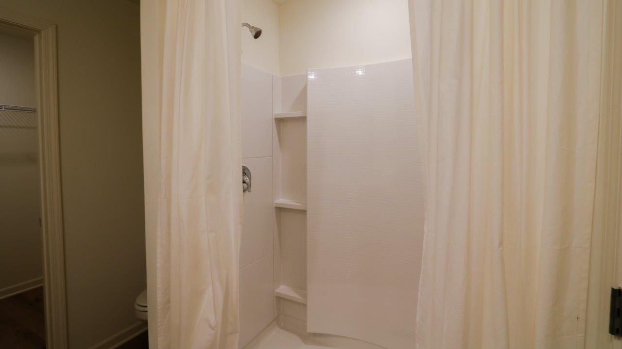 Fresh and bright bathroom featuring modern fixtures and warm wood accents, perfect for a relaxing space.