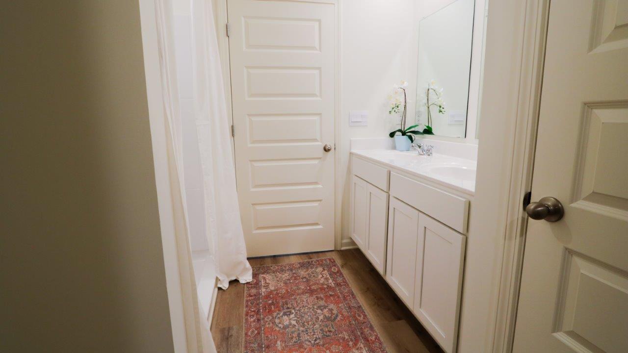 Fresh and bright bathroom featuring modern fixtures and warm wood accents, perfect for a relaxing space.