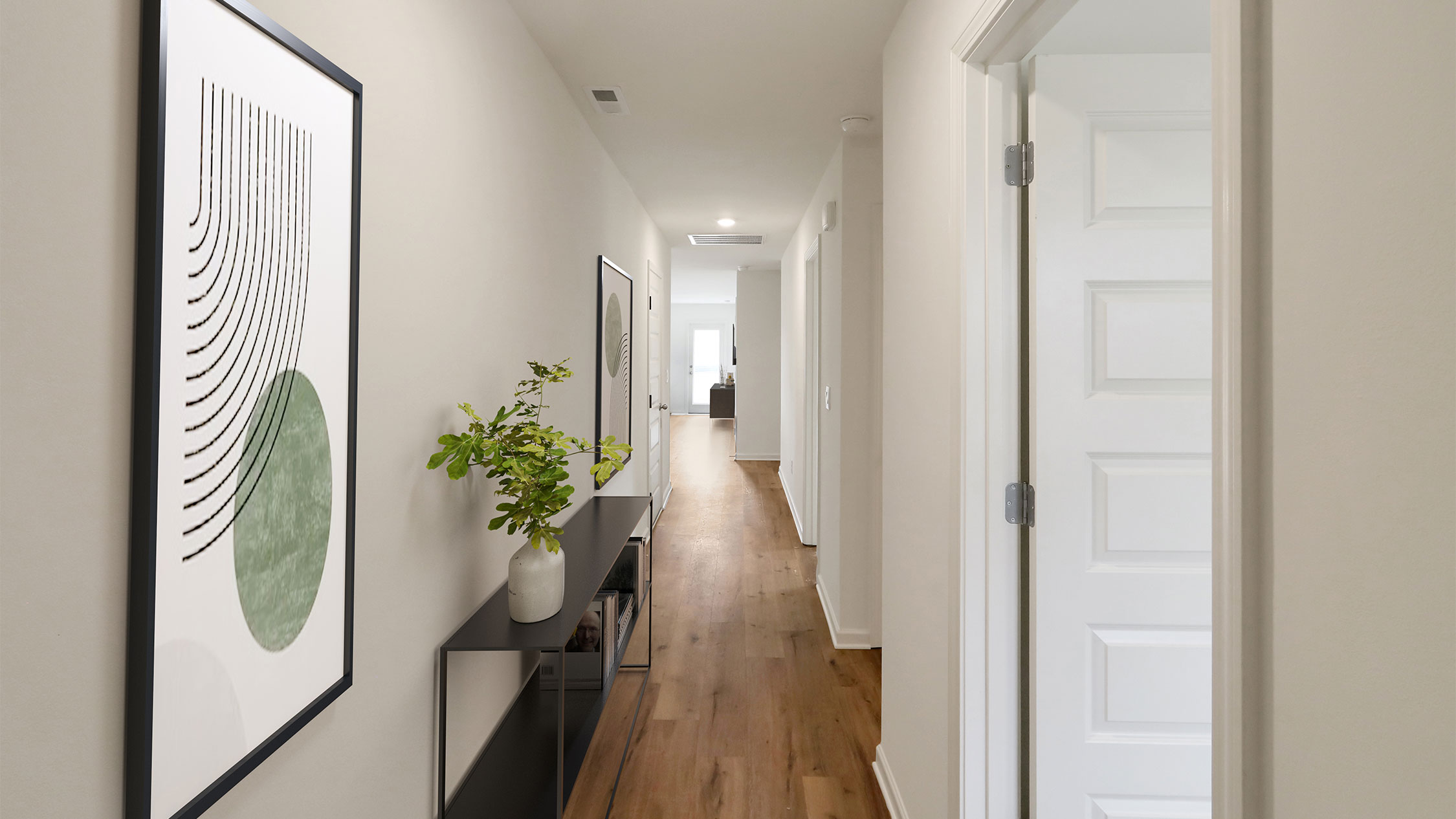 A hallway featuring a white door and a polished wooden floor, creating a bright and inviting atmosphere.    2. A well-lit hallway showcasing a white door against a backdrop of warm wooden flooring, enhancing the space's elegance.   3. A hallway with a sleek white door and rich wooden flooring, offering a clean and welcoming aesthetic.