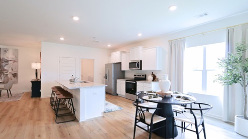 Destin – Kitchen – 1 – the open concept kitchen features a large island, white cabinets, stainless steel appliances and opens the full breakfast nook