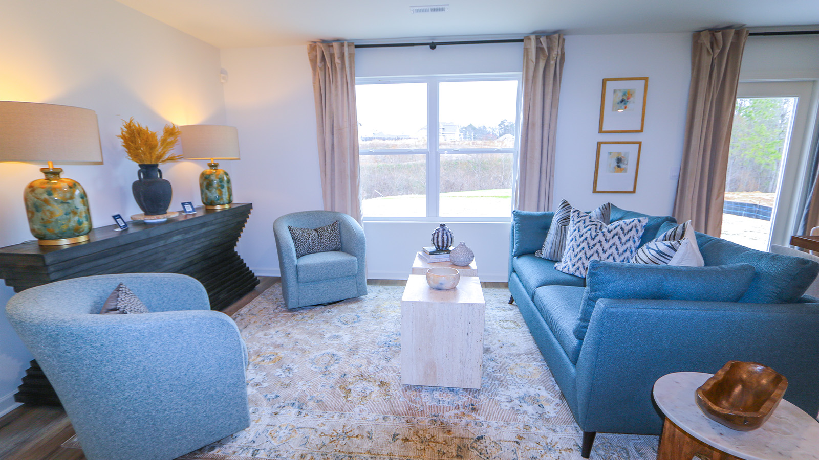 The living room is spacious and includes a comfortable couch, two poofs, a coffee table, a media console, and an accent chair.