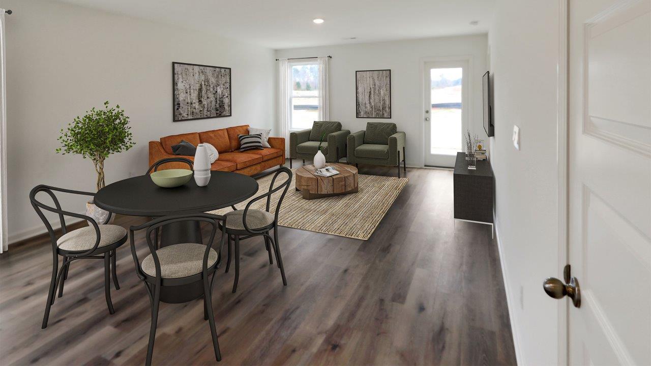 A modern living room and dining area in a newly constructed home, featuring stylish furniture and bright decor.