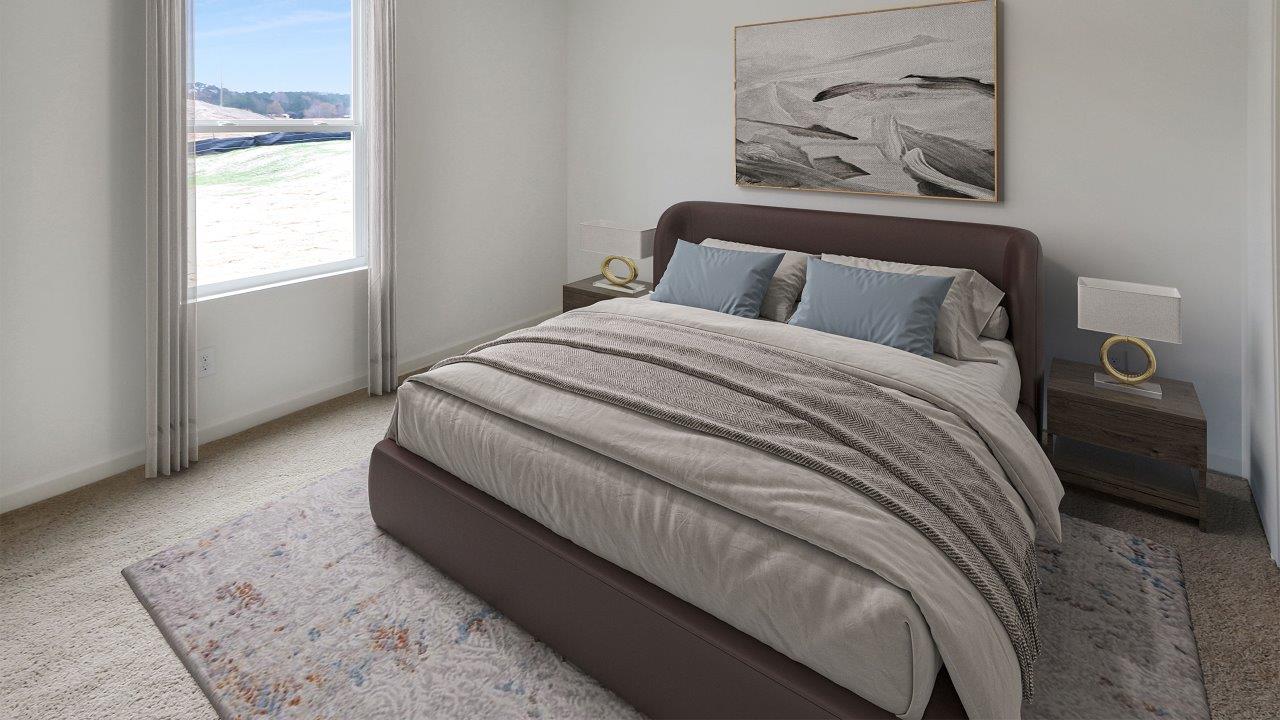 A cozy bedroom featuring a bed, a nightstand, and a window allowing natural light to enter the space.