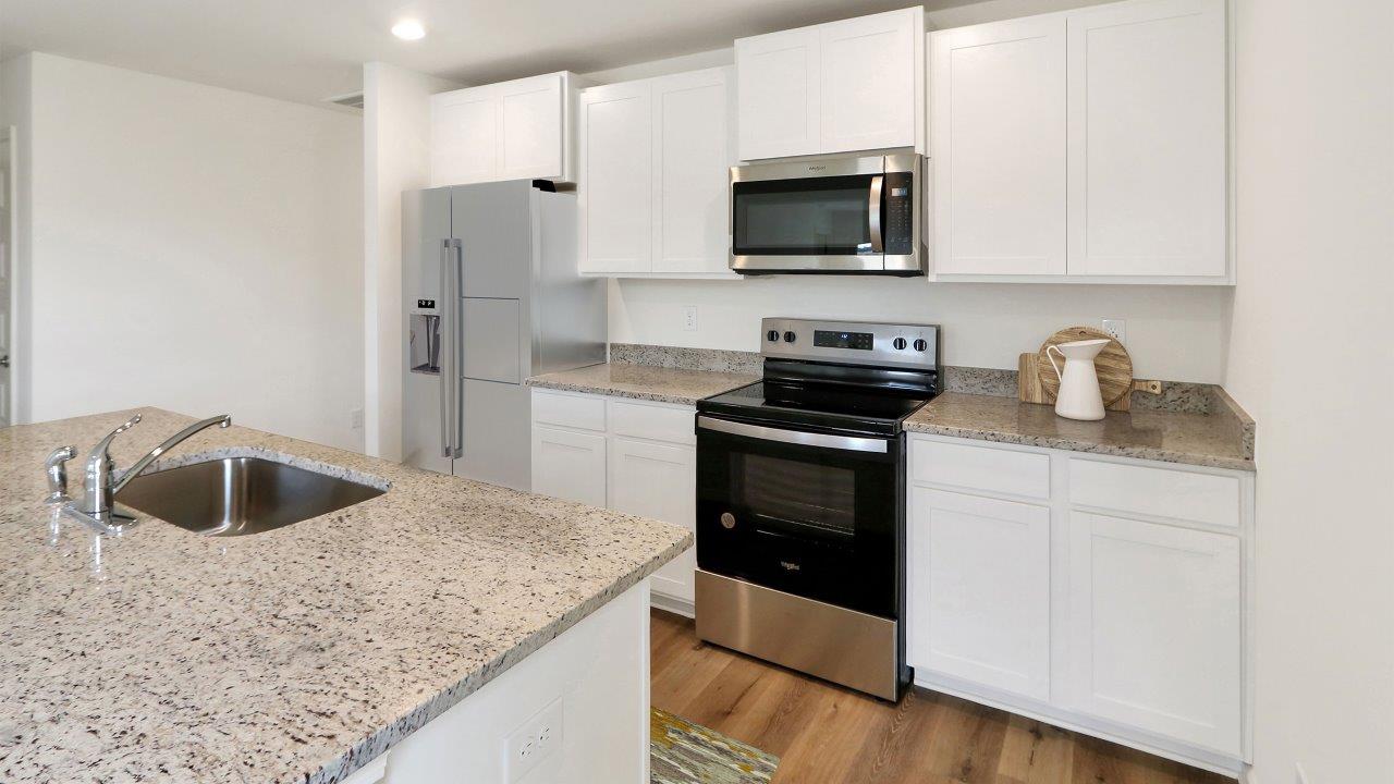 A modern kitchen featuring stainless steel appliances and elegant granite countertops, showcasing a sleek and stylish design.