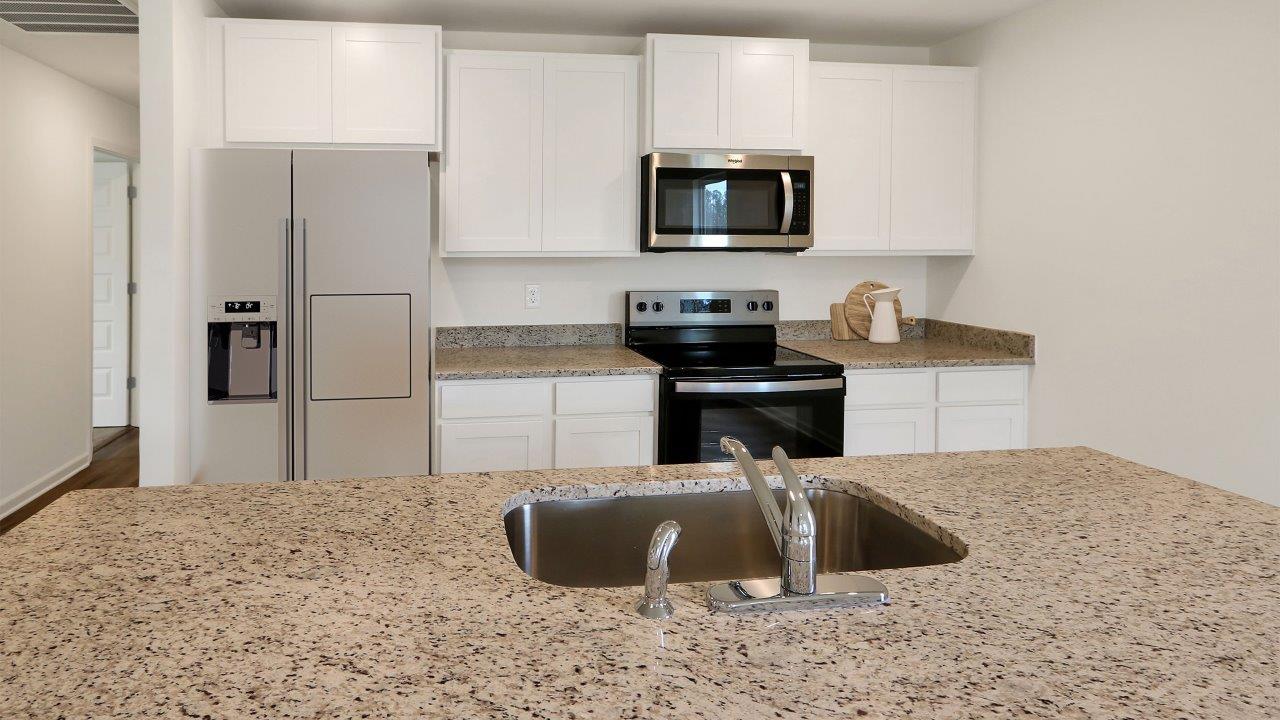 A modern kitchen featuring stainless steel appliances and elegant granite countertops, showcasing a sleek and stylish design.