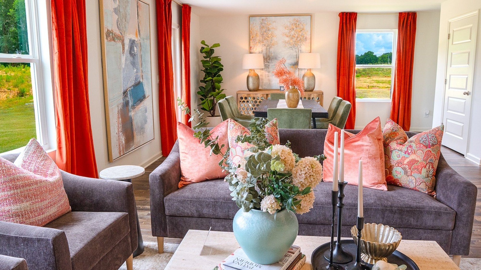 The spacious living room, shown here staged with a large sectional, opens up to the open concept dining and kitchen areas.