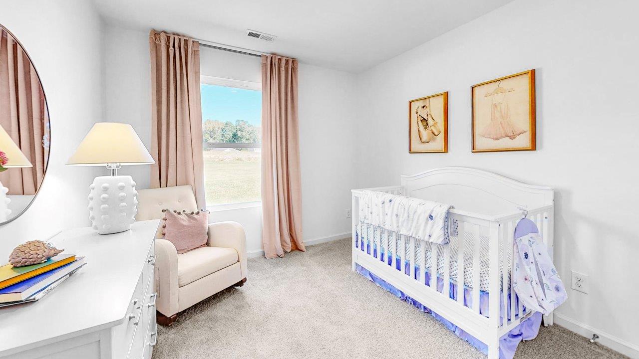 The second bedroom is staged here as a spacious nursery.
