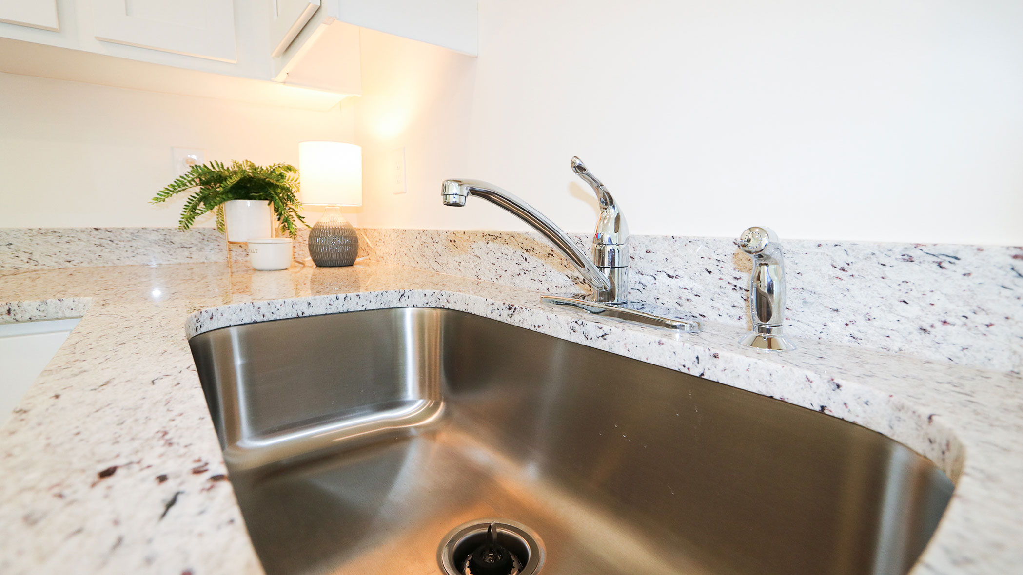 A kitchen featuring white cabinets and granite countertops, captured from a different angle to showcase its spacious design.