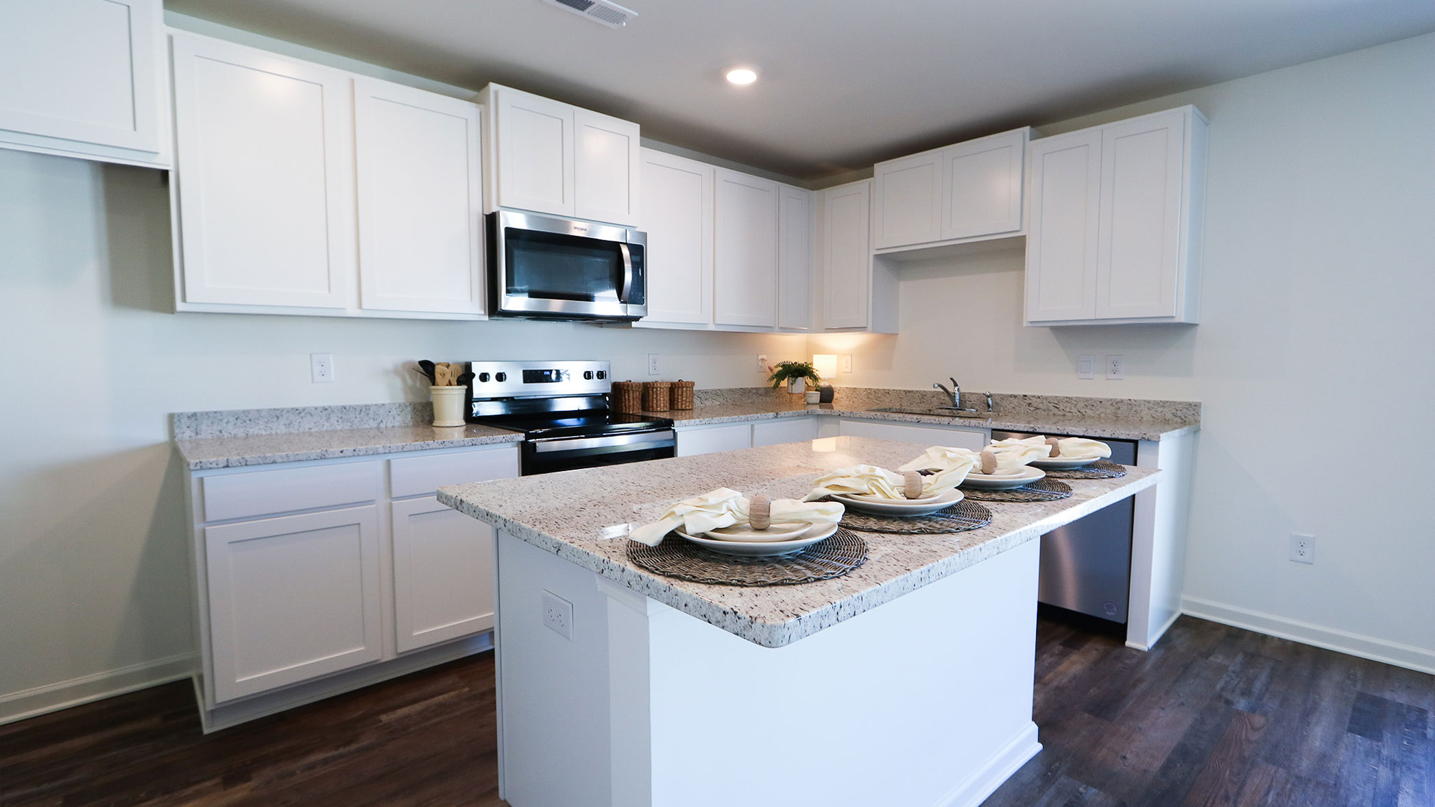 A contemporary kitchen showcasing white cabinets and granite countertops for a polished look.