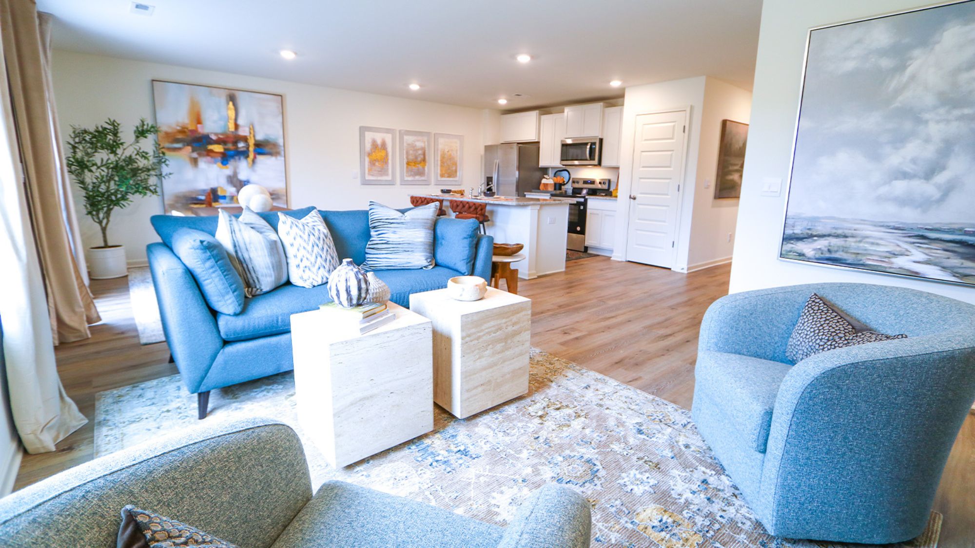 Welcome to the spacious living room! You'll find a comfortable couch, two poofs, a coffee table, a media console, and an accent chair in this inviting space.
