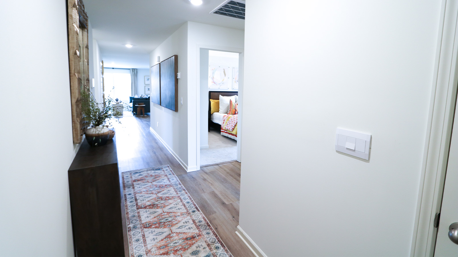 The primary bedroom features a spacious king-sized bed and two large windows.