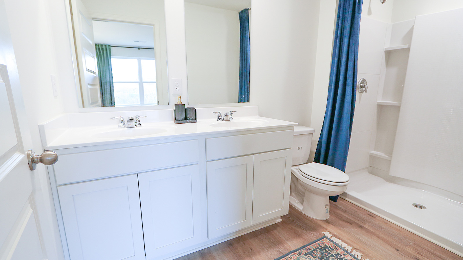 The primary bedroom features a spacious king-sized bed and two large windows.