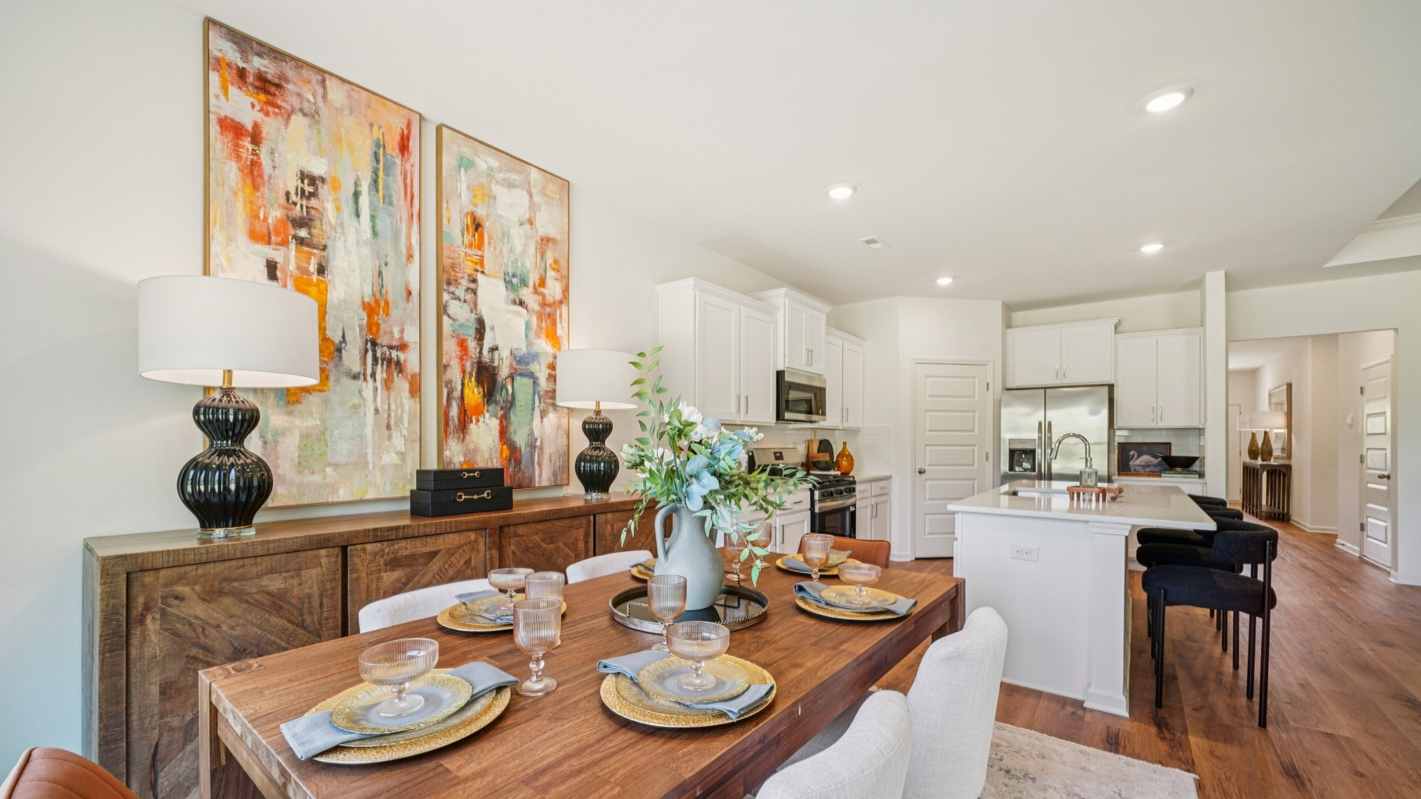 The kitchen is a spacious open concept area with stainless steel appliances. It includes an oversized kitchen island with barstools for seating and food preparation. Additionally, there is a convenient walk-in pantry for storage.