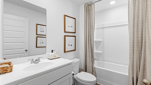The second bedroom is equipped with a bed accompanied by two nightstands. Additionally, it includes a large window that provides ample natural light. Furthermore, there is an accent chair for added comfort and style.