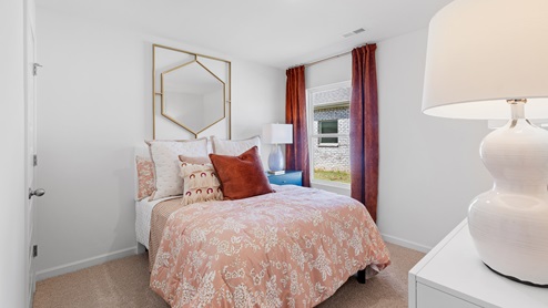 The second bedroom is equipped with a bed accompanied by two nightstands. Additionally, it includes a large window that provides ample natural light. Furthermore, there is an accent chair for added comfort and style.