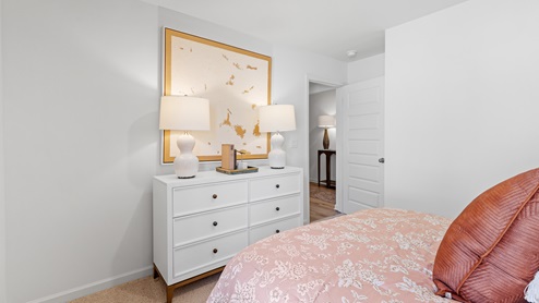 The second bedroom is equipped with a bed accompanied by two nightstands. Additionally, it includes a large window that provides ample natural light. Furthermore, there is an accent chair for added comfort and style.