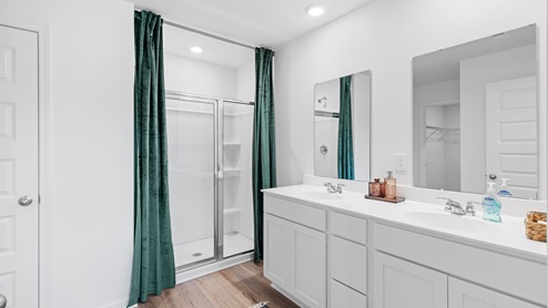The spacious primary bathroom includes a large walk-in area with a double vanity equipped with two sinks. Additionally, it boasts a luxurious walk-in shower for added comfort and convenience. The large walk-in primary bathroom features a double vanity with 2 sinks, and a walk-in shower.