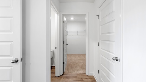 The walk-in closet in the primary bedroom is situated at the rear of the bathroom. It offers generous space for storing clothes and accessories.