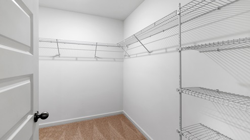 The walk-in closet in the primary bedroom is situated at the rear of the bathroom. It offers generous space for storing clothes and accessories.