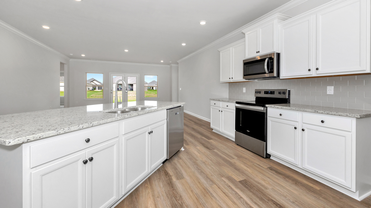 Kitchen island with painted cabinets and stainless steel appliances
